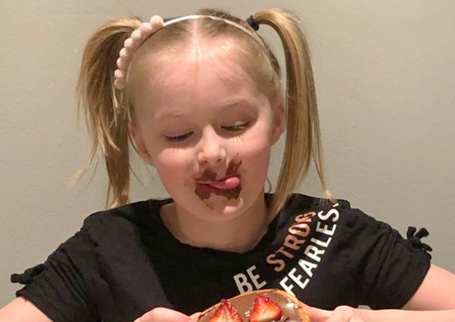 Child eating pancakes on Shrove Tuesday