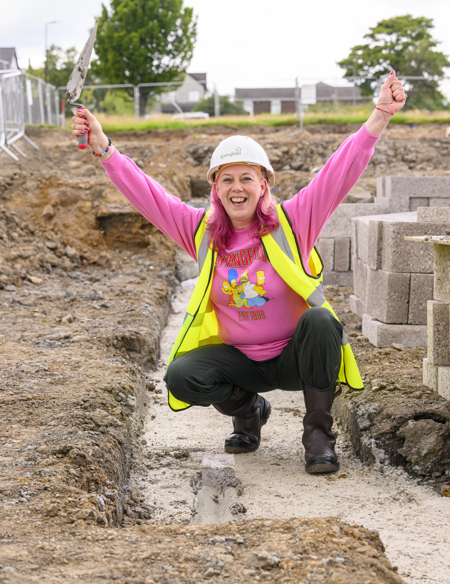 Deans South resident, Kerry, celebrating after laying the first brick of her new home. 